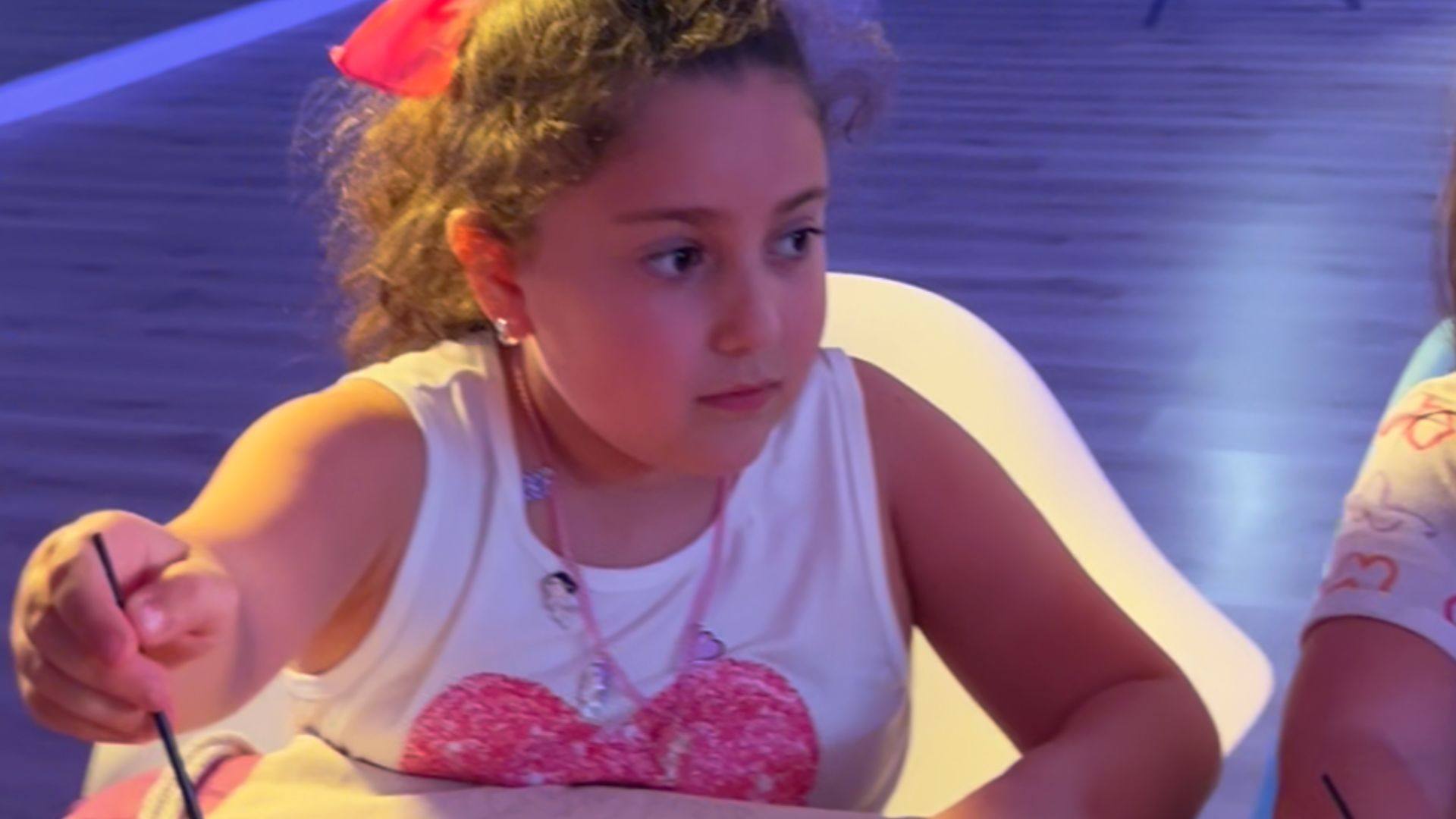 Niña concentrada pintando en una fiesta de cumpleaños
