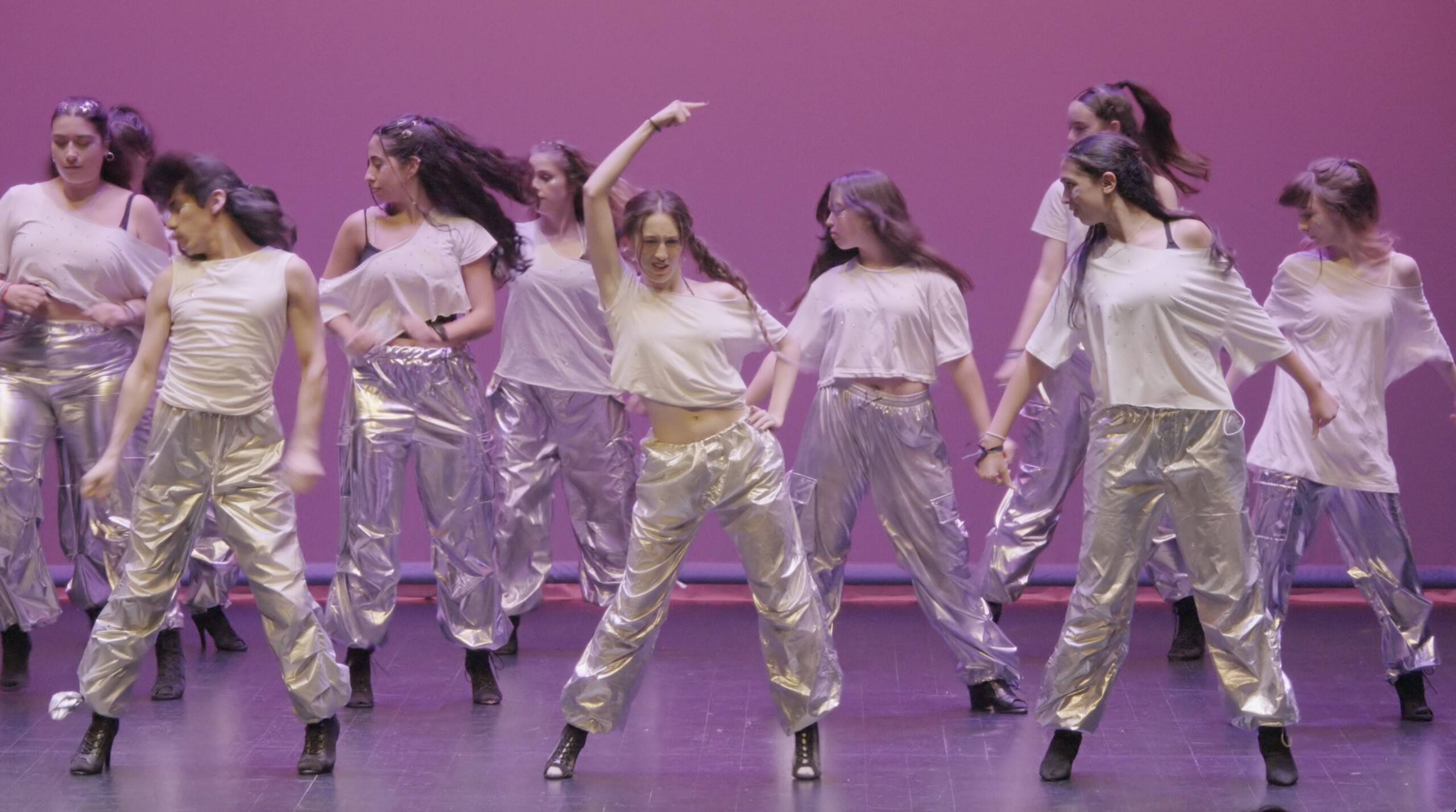 Coreografía de heels en el escenario con luz rosa